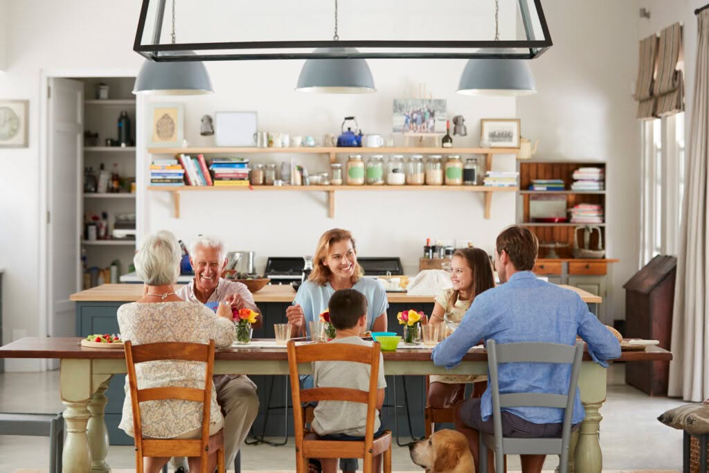 Familie sitzt am Esstisch in der Küche.